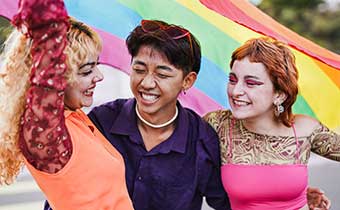people with pride flag behind them