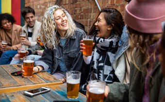 A group of friends at a restaurant all drinking pints of beer