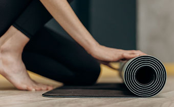 woman rolling out a yoga mat